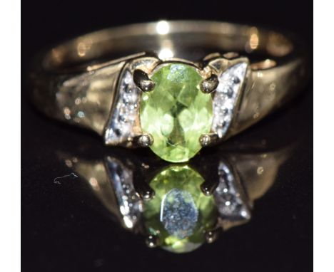 A 9ct gold ring set with an oval cut peridot and diamonds, size M, 2.5g