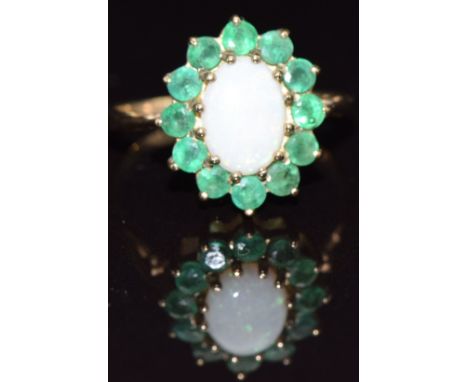 A 9ct gold ring set with an opal surrounded by emeralds, size K, 1.9g