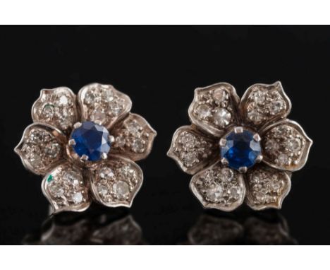 A pair of sapphire and diamond floral cluster earrings: each with a central circular sapphire 4.6mm diameter, within a petal 