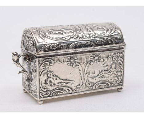 A Continental silver ring casket, in the form of a trunk: stamped marks, having a domed hinged lid and embossed decoration to
