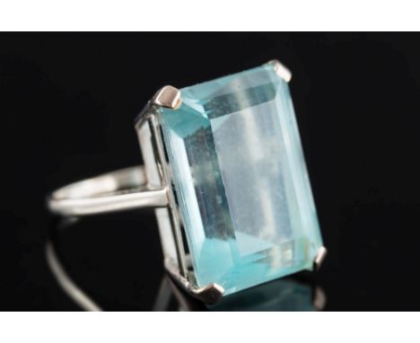 An 18ct white gold and aquamarine single-stone ring: the step-cut aquamarine approximately 20.6mm long x 15.4m wide in a four