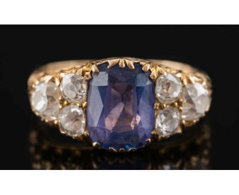 A late 19th century gold, sapphire and diamond seven-stone ring: with central cushion-shaped sapphire approximately 10mm long