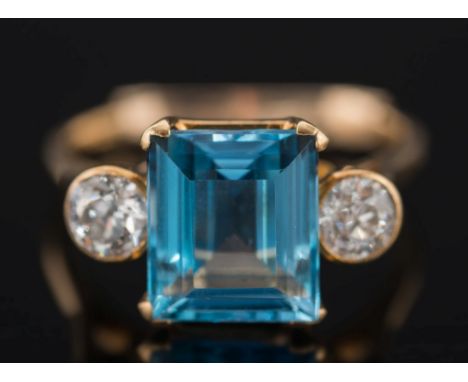 A gold, aquamarine and diamond three-stone ring: with central rectangular aquamarine, approximately 10mm x 9mm in four-claw s