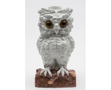 A Continental porcelain 'owl' table lamp: with inset glass eyes modelled standing on a log, blue crossed swords to base, late
