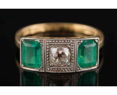 An 18ct gold, Art Deco style emerald and diamond three stone ring:, the central, cushion shaped, old-cut diamond approximatel