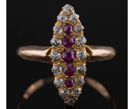 A gold, ruby and diamond marquise shaped cluster ring: the central, single row of graduated rubies, within a surround of circ