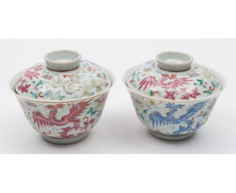 A pair of Chinese famille rose 'phoenix' bowls and one cover: each painted with three phoenix in flight amongst lotus and oth