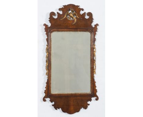 A 19th Century walnut and partly gilt fret cut wall mirror:, surmounted by a figure of a ho-ho bird, the plate within a gilt 