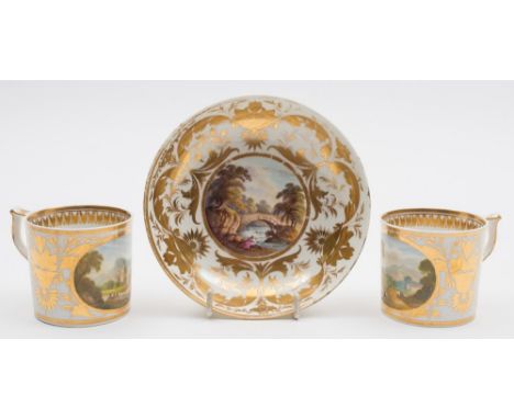 A pair of Derby topographical coffee cans and a saucer: the cans of cylindrical form with wishbone handles decorated with ova
