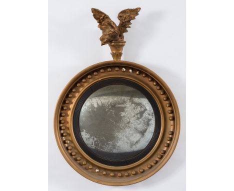 A 19th Century (or later) gilt decorated circular convex mirror:, surmounted by a figure of an eagle with outspread wings, th