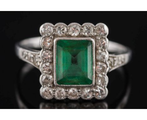 An early / mid 20th century platinum, emerald and diamond rectangular cluster ring: with central rectangular emerald 6.8mm lo