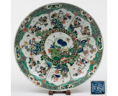 A Chinese famille verte dish: painted with a central circular panel encircled with eight foliate panels of pierced rockwork, 