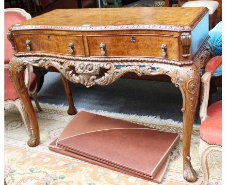 A Burr Walnut Two Drawer Side Table, first half 20th century, of serpentine form, heavily carved and on cabriole supports, 10