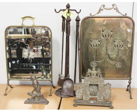 An Art Nouveau Brass Fire Screen; together with a similar mirrored example, a fireside companion set, a cast iron door stop, 