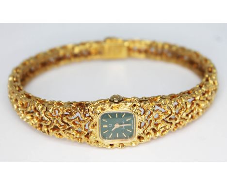 A 1967 ladies hallmarked 18ct gold Omega bracelet watch, reference 8180, with green signed dial, hour markers and hands in go
