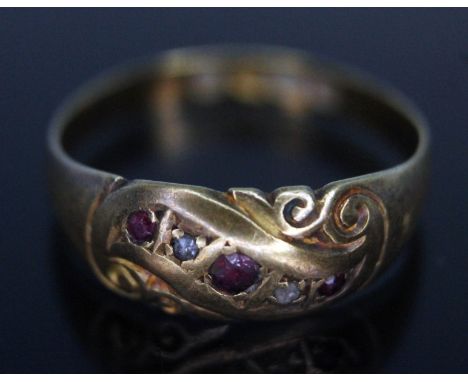 A hallmarked 18ct gold, scroll setting set with colourless and red stones, gross wt. 1.78g, size K.  
