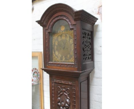 A late Victorian oak long case clock with domed hood, brass and silvered dial with gothic numerals and rolling moon, the move