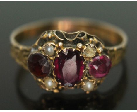 A George III 15ct gold ring set with two purple almandine garnet and split pearls, hallmarked Birmingham 1821, gross wt. 2.26