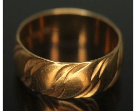 A hallmarked 18ct gold wedding band with wavy design to exterior, wt. 4.61g, size K.  