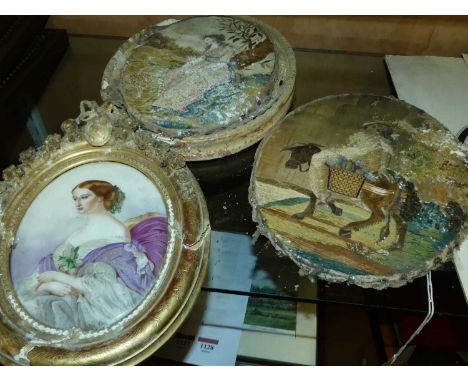 A pair of 19th century silkwork panels, each framed as ovals (a/f); together with a continental porcelain portrait plaque in 