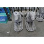 Pair of concrete dogs laying down