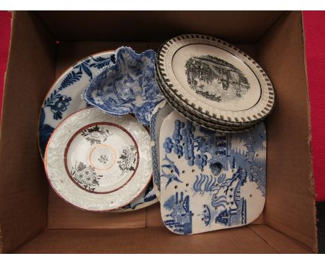 A tin glazed blue and white plate, two transferware square drainers/teapot stands, four bat printed ribbon plates some with i