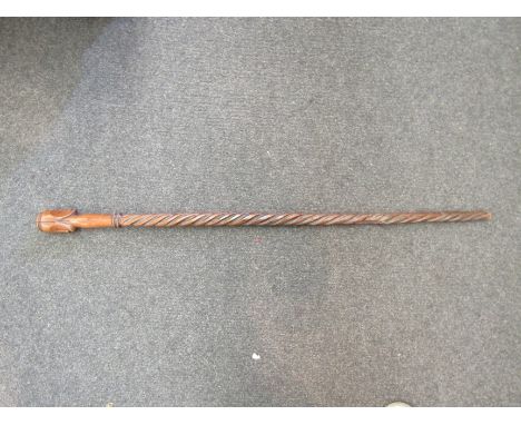 An African, possibly Gabonese, staff bearing twin masks to handle and twisted carving to shaft.  Length 90.5cm.  Provenance: 