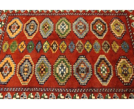 An Iranian wool carpet, on red ground, 175 cm x 206 cm.