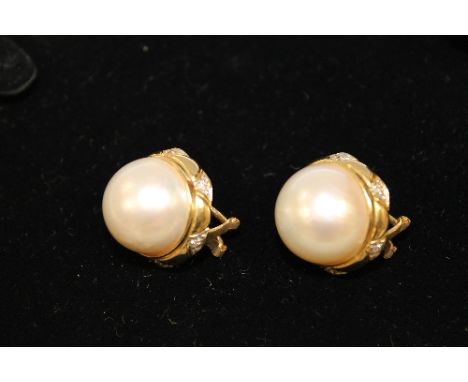 A pair of 18ct gold large mabe pearl earrings, each set with diamonds. (2) CONDITION REPORT: Good condition. 12g gross, width