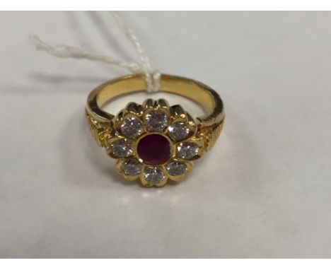 A 22ct gold ruby and diamond cluster ring.