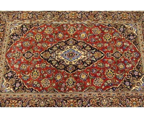 An Iranian wool carpet, on red ground, 169 cm x 104 cm.