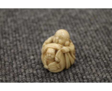 A nineteenth century ivory netsuke depicting two figures, signed, width 3 cm. CONDITION REPORT: Good condition and quality.