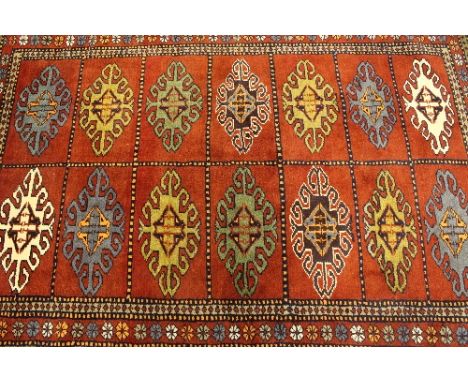 An Iranian wool carpet, on red ground, 174 cm x 124 cm.