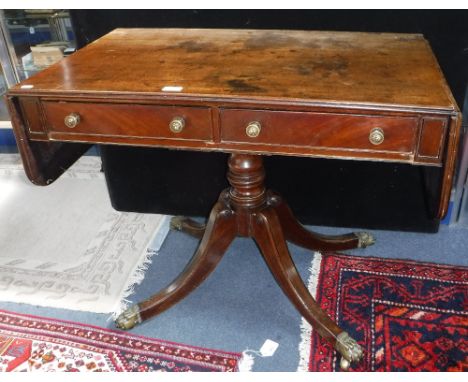 A GEORGE III MAHOGANY SOFA TABLE on turned column with four downswept legs and brass animal paw cap castors, 36" wide (closed