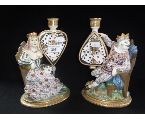 A PAIR OF MINTON'S FIGURES OF A KING AND QUEEN holding a heart and spade, decorated with playing cards, topped by candle hold