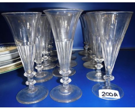 A SET OF FIFTEEN SIMILAR 19TH CENTURY CLEAR GLASS FLUTES with panel cut bodies and circular feet