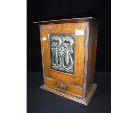 A LATE VICTORIAN ART NOUVEAU STYLE OAK SMOKER'S CABINET with embossed copper panel to the front