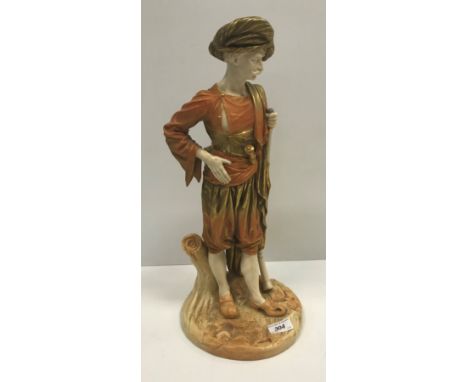 A Royal Worcester buff ware porcelain figure of a Turk with rifle stood by a tree trunk, No'd. 2038, possibly after the origi