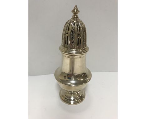 A George V silver sugar caster with pierced domed top over a squashed baluster shaped body, raised on a circular foot (by Seb