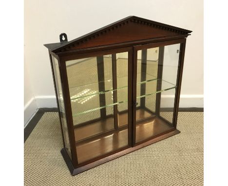 A Victorian mahogany glazed hanging display cabinet with architectural dentil cornice over two doors enclosing a mirrored bac