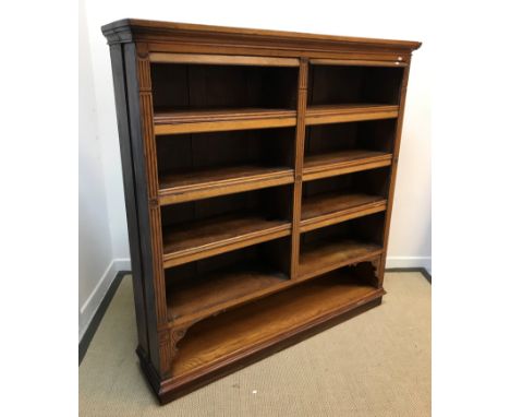 A Victorian oak open bookcase with two banks of adjustable shelving each with an upper fall flap interspersed by floral medal