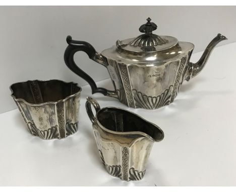 A Victorian silver tête à tête three piece tea set of embossed and fluted form, comprising teapot, cream jug and sugar basin 