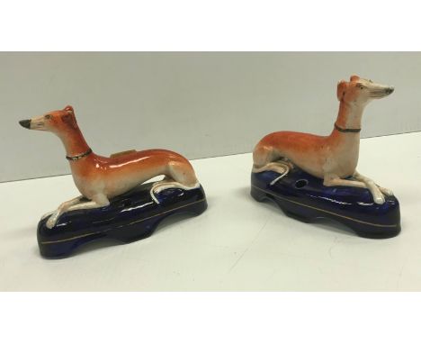 A pair of 19th Century Staffordshire Greyhound inkwells, 15.5 cm long x 11.6 cm high, together with a pair of Staffordshire "