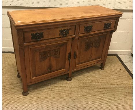 A Victorian carved oak sideboard or dresser, the plain top above two drawers and two cupboard doors with stylised carved flor