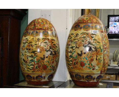 A pair of large Chinese Chinoiserie decorated ceramic Eggs decorated with birds and flora predominantly famille vert and fami