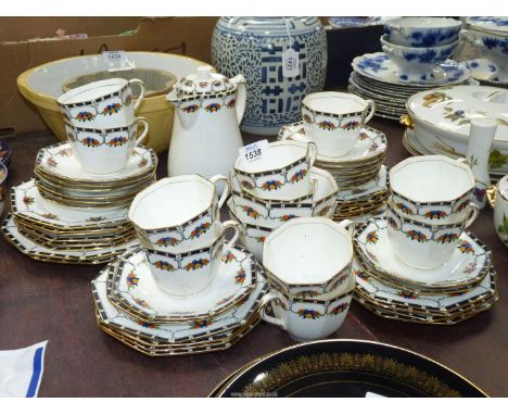 A large Delphine china tea service, octagonal shaped with raised swags of fruit, black white and green rims on white ground, 