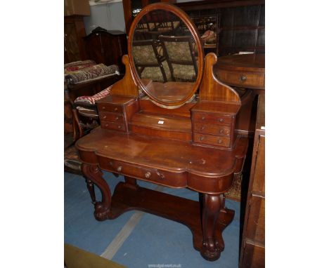 A Mahogany Duchess Dressing Table, the oval mirror rasied on a plinth with a central hinged lidded compartment flanked on eac