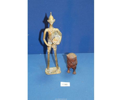 A small heavy cast metal model of an Owl and a brass figure of a tribesman beating a drum.