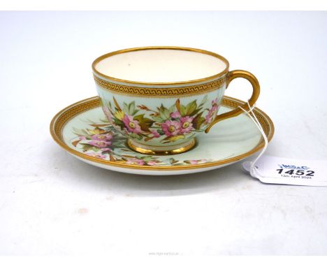 A delicate Royal Worcester porcelain cabinet cup and saucer painted with pink  flowers with gilt highlights, on duck egg blue