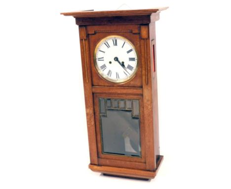 An early 20thC mahogany cased wall clock, with a white Roman numeric dial and a glazed rectangular lower panel, on a stepped 